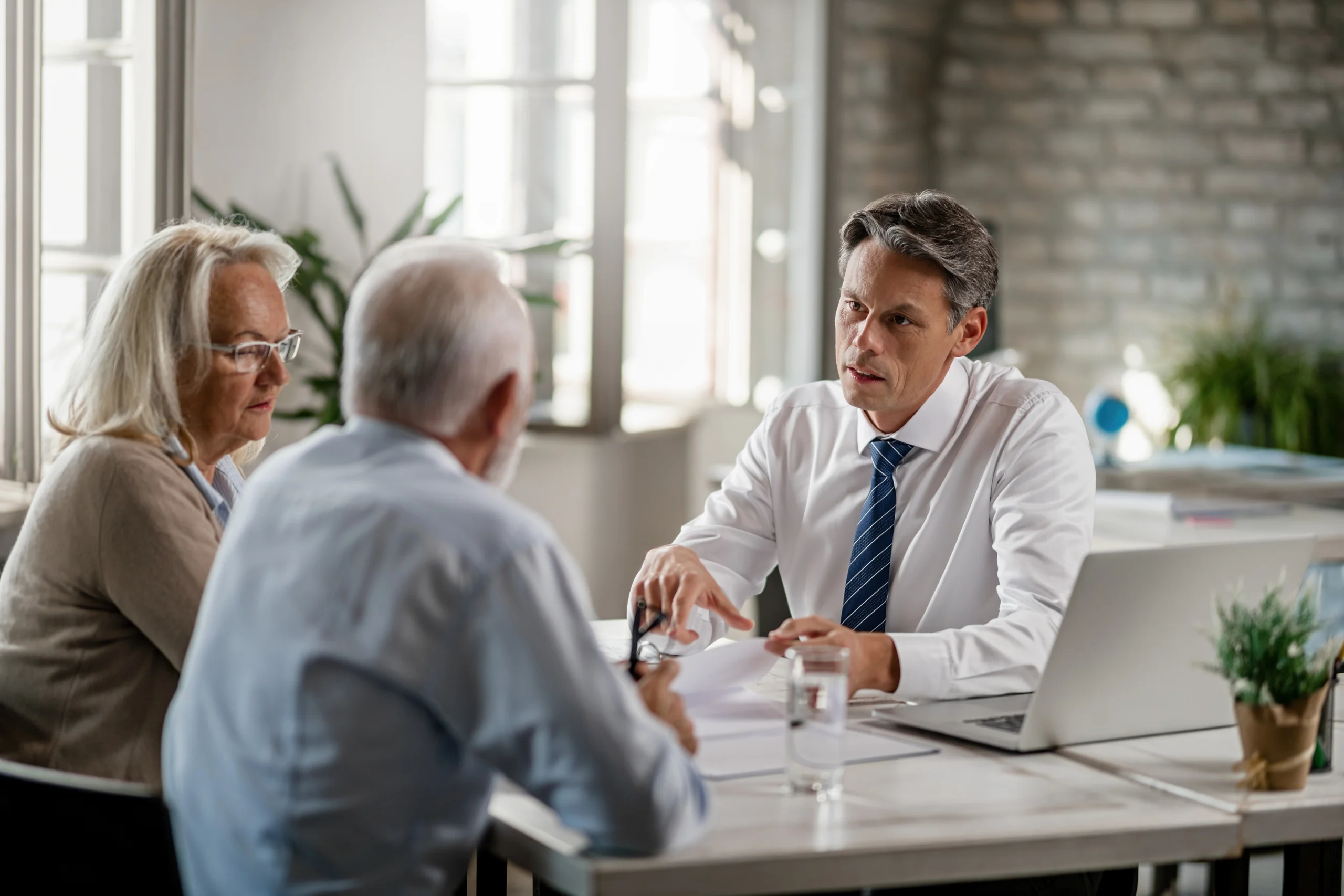 mid-adult-insurance industry -agent-with-mature-couple-analyzing-financial-reports-communicating-meeting-office