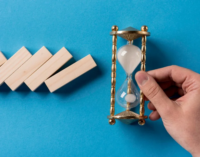 top-view-domino-pieces-with-businessman-holding-hourglass